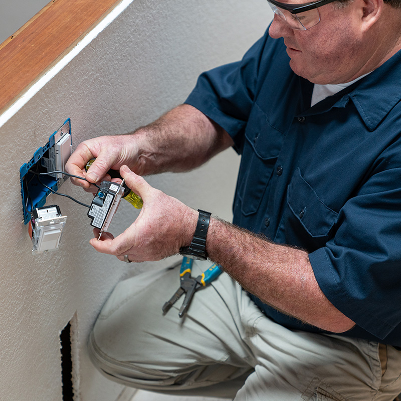 Electrician installing light switch in home