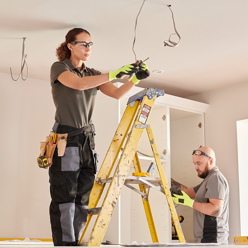 female electrician working in a kitchen remodeling